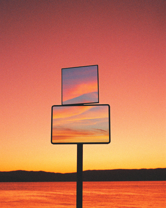 Mirrors reflecting a sunset scenery with sea and sky colored in orange and pink.