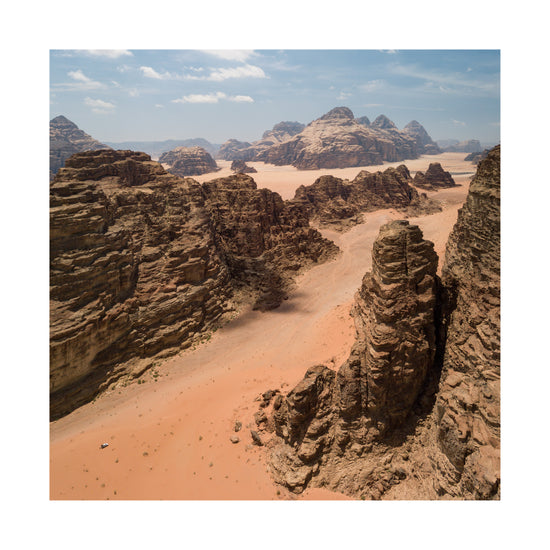Landscape photograph with brown cliffs and rusty red dirt roads.