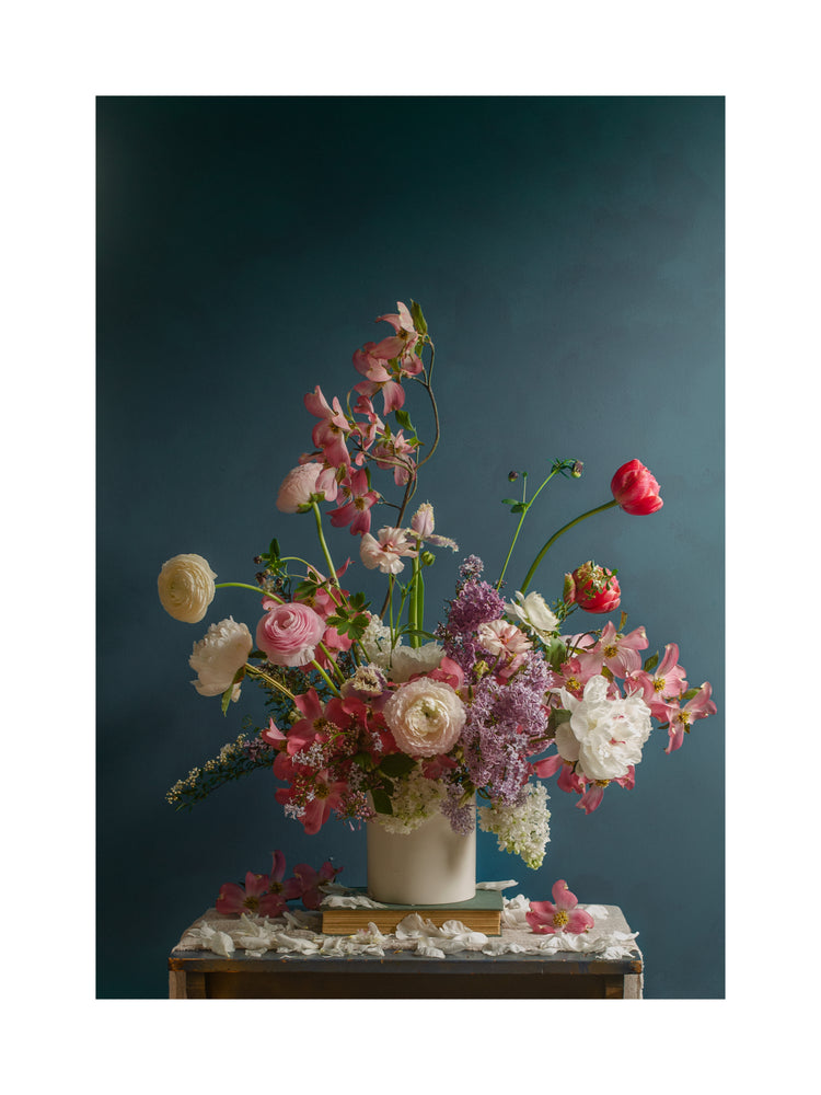 The Spring Ballet Poster showcases a vibrant floral arrangement with pink roses, white peonies, lilacs, and a red tulip in a white vase against a teal background, accented by scattered white petals.