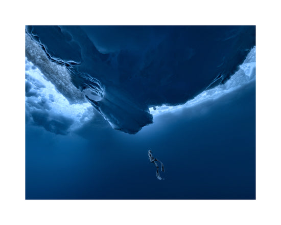 Lonely free-diver swimming towards a surface covered in ice.