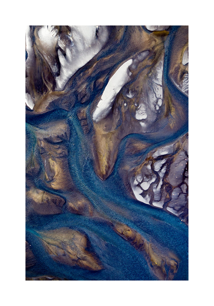 Blue streams rippling down a mountain path covered in snow.