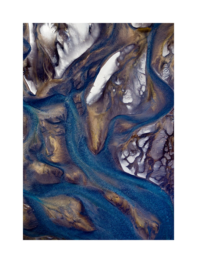 Blue streams rippling down a mountain path covered in snow.
