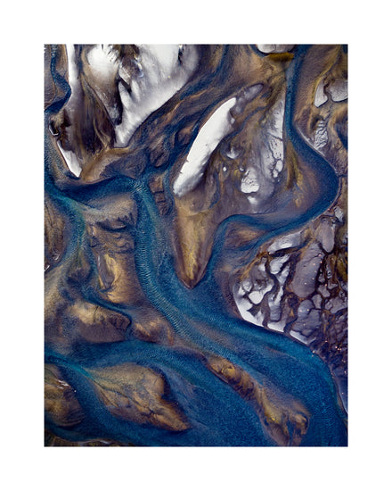 Blue streams rippling down a mountain path covered in snow.