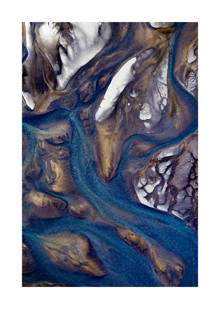 Blue streams rippling down a mountain path covered in snow.