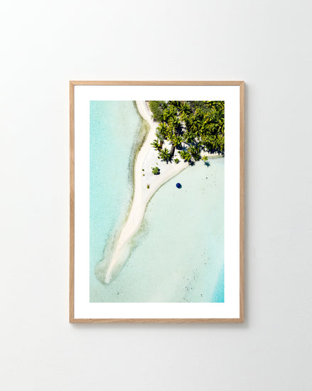 The Piña Colada as a Place Poster shows a framed aerial view of a tropical island with white sandy beaches, clear blue water, and lush green foliage—ideal for imagining sipping a cool drink while admiring the shallow, turquoise waters.