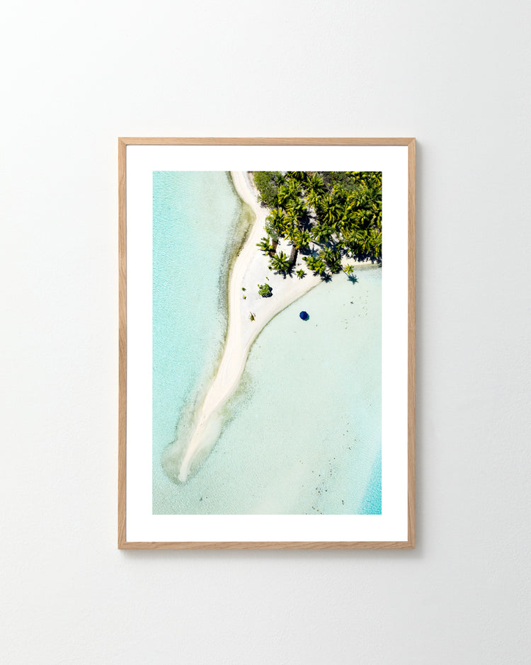 The Piña Colada as a Place Poster shows a framed aerial view of a tropical island with white sandy beaches, clear blue water, and lush green foliage—ideal for imagining sipping a cool drink while admiring the shallow, turquoise waters.