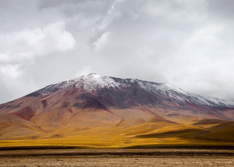 Colorful mountain with a snowcapped peak touching the sky up the sky.