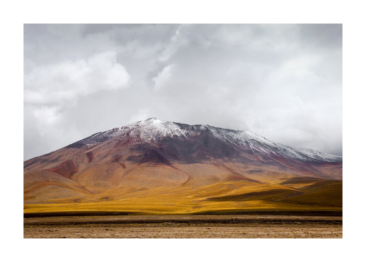 Colorful mountain with a snowcapped peak touching the sky up the sky.