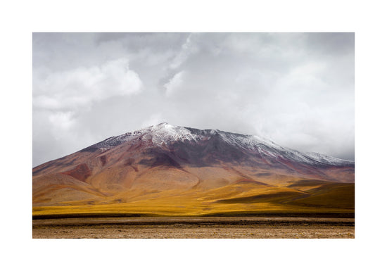 Colorful mountain with a snowcapped peak touching the sky up the sky.