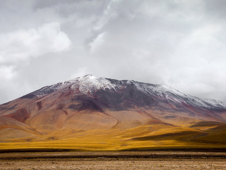 Colorful mountain with a snowcapped peak touching the sky up the sky.
