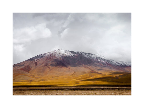Colorful mountain with a snowcapped peak touching the sky up the sky.