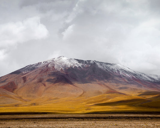 Colorful mountain with a snowcapped peak touching the sky up the sky.