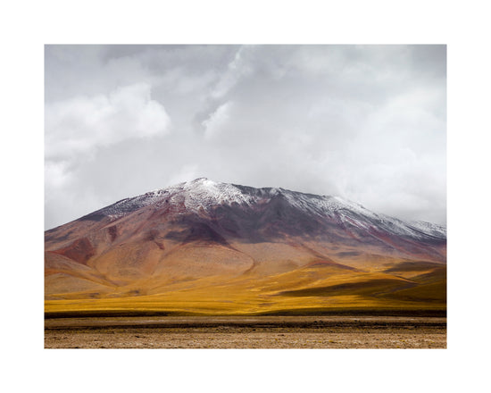 Colorful mountain with a snowcapped peak touching the sky up the sky.