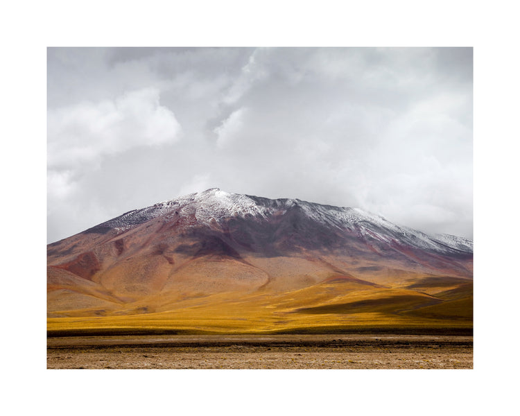 Colorful mountain with a snowcapped peak touching the sky up the sky.