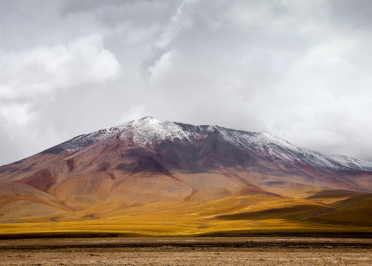 Colorful mountain with a snowcapped peak touching the sky up the sky.