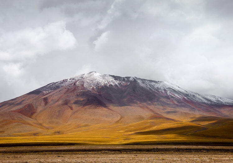 Colorful mountain with a snowcapped peak touching the sky up the sky.