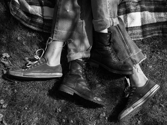 The entangled feet of a couple lying down on a picnic blanket.
