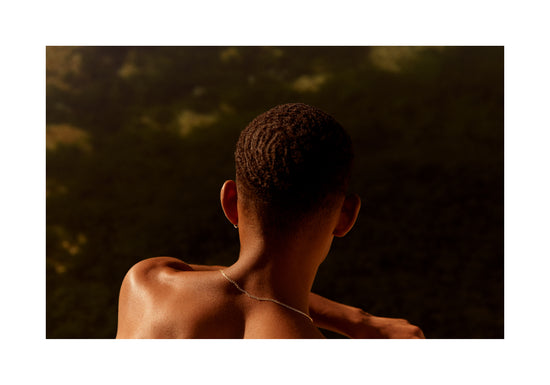Smooth skinned man looking out over a blurry landscape.