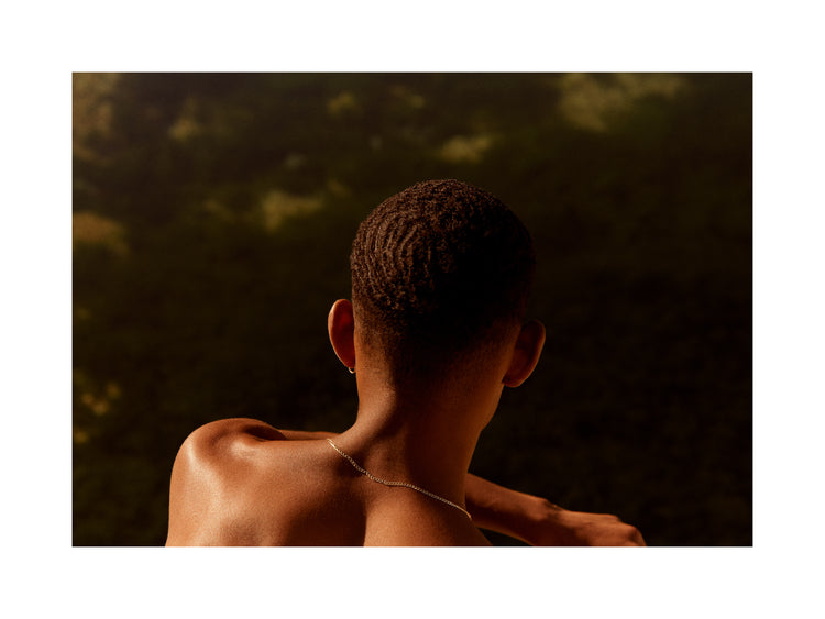 Smooth skinned man looking out over a blurry landscape.