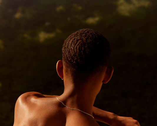 Smooth skinned man looking out over a blurry landscape.