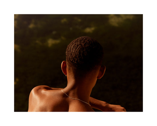 Smooth skinned man looking out over a blurry landscape.