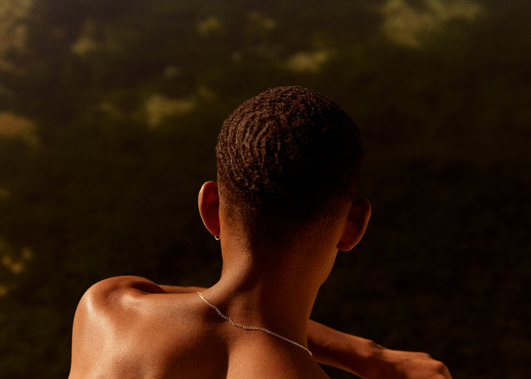 Smooth skinned man looking out over a blurry landscape.