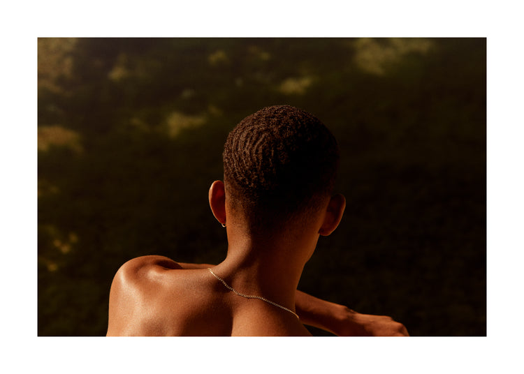 Smooth skinned man looking out over a blurry landscape.