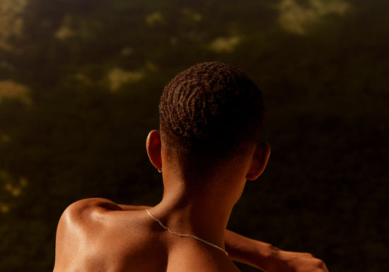 Smooth skinned man looking out over a blurry landscape.