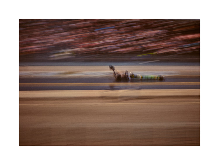 Blurry image of a cast going fast on a race car track.