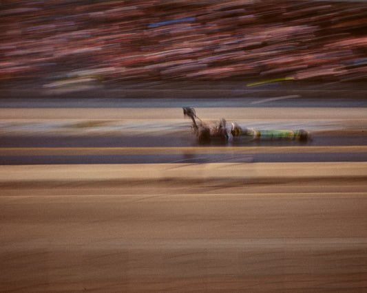Blurry image of a cast going fast on a race car track.