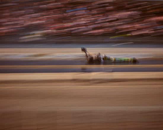 Blurry image of a cast going fast on a race car track.