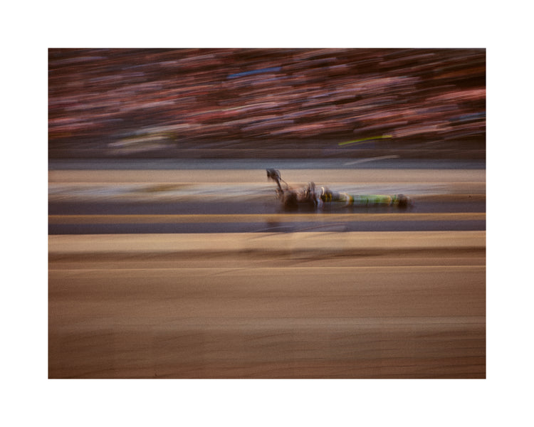 Blurry image of a cast going fast on a race car track.