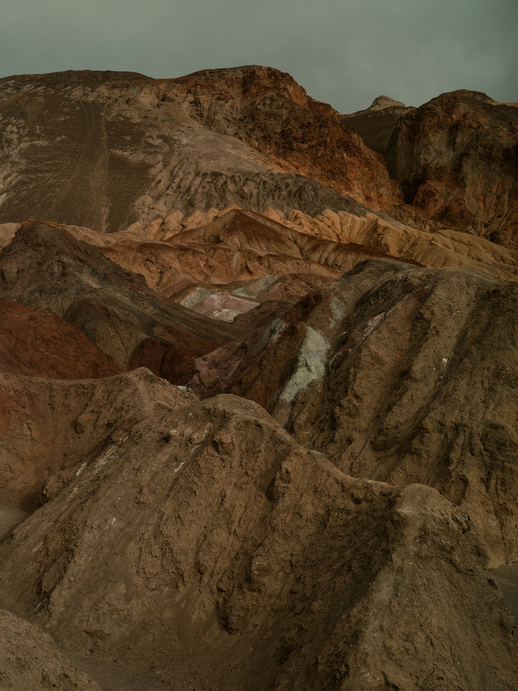 Rough mountain scenery with brown and orange cliffs captured from above.