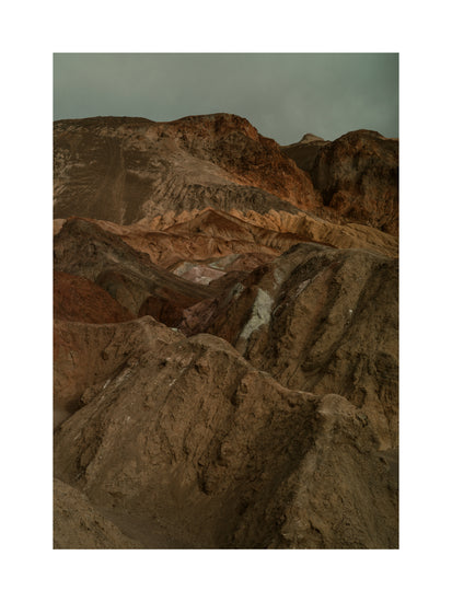 Rough mountain scenery with brown and orange cliffs captured from above.