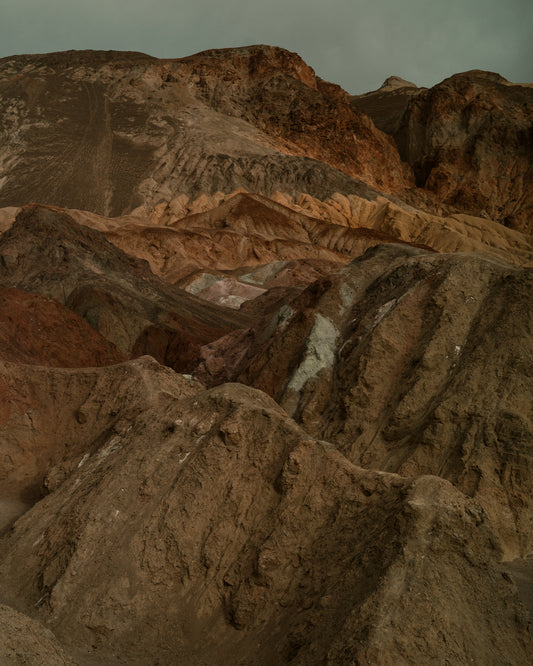 Rough mountain scenery with brown and orange cliffs captured from above.