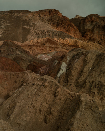 Rough mountain scenery with brown and orange cliffs captured from above.