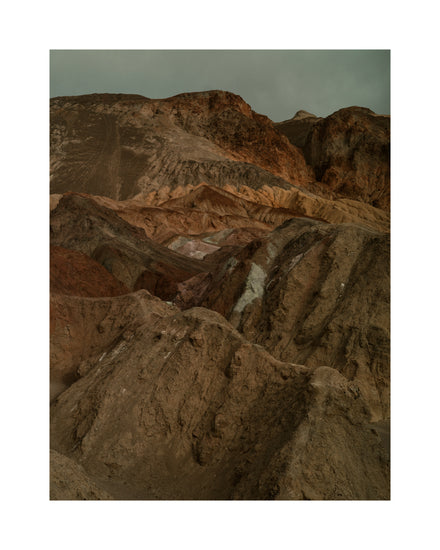 Rough mountain scenery with brown and orange cliffs captured from above.