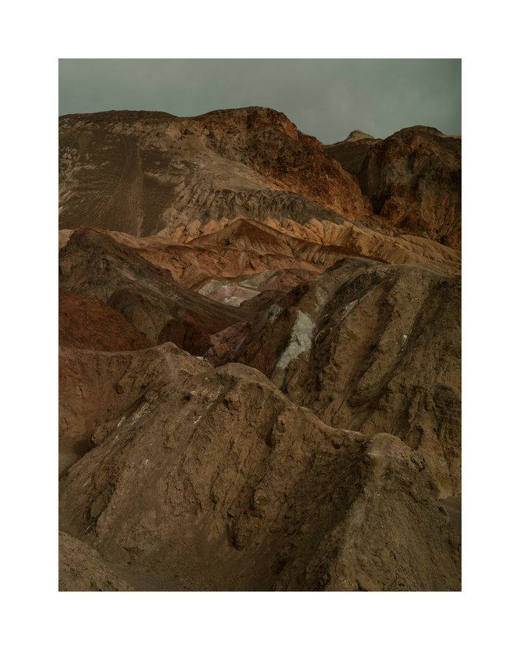 Rough mountain scenery with brown and orange cliffs captured from above.
