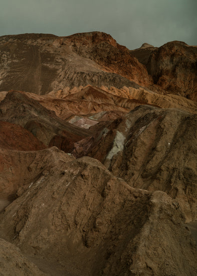 Rough mountain scenery with brown and orange cliffs captured from above.