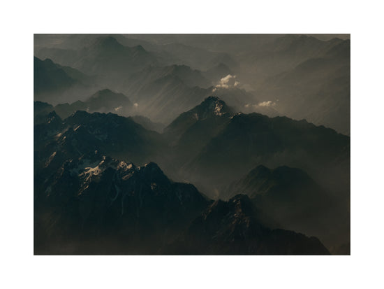 Birds view of a dark mountain scenery obscured by white mist.