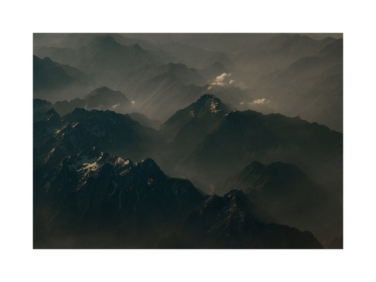 Birds view of a dark mountain scenery obscured by white mist.