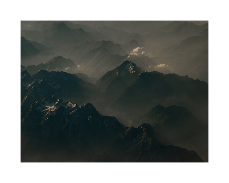 Birds view of a dark mountain scenery obscured by white mist.