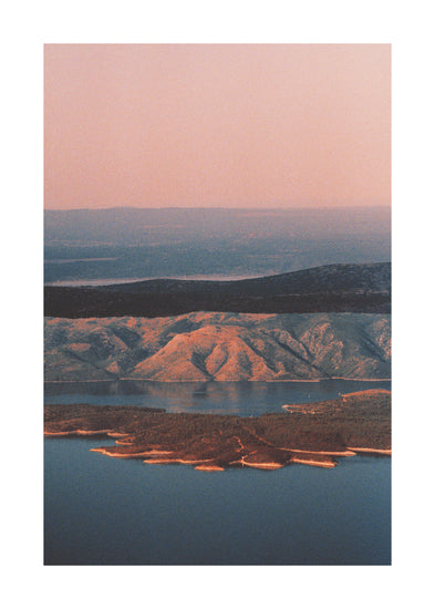 Landscape scenery with mountains and forests and lakes under crimson sky.