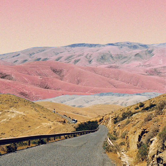 Technicolor scenic landscape with pink and purple mountains under a pink sky.