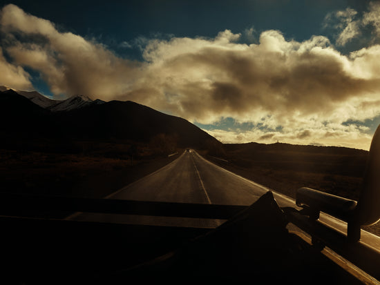 Road going through a landscape captured from the back of a car.