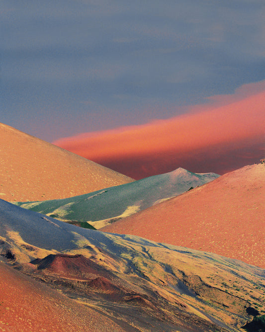 Colorful mountain scenery sparkling under a blue sky with crimson clouds.