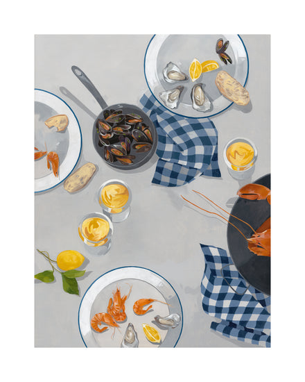 Top-down view of a table with seafood plates featuring shrimp, oysters with lemon wedges, and mussels in a pot. Blue checkered napkins, bread slices, and two Break Out of the Shell I posters are in the backdrop, completed by two glasses of creamy drinks alongside the dishes.