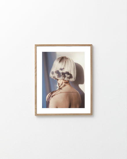 The back of a bare shouldered woman with a white page.