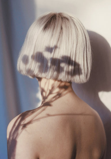 The back of a bare shouldered woman with a white page.