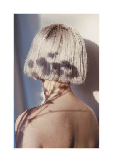 The back of a bare shouldered woman with a white page.